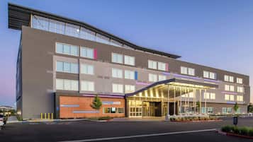 Un hotel moderno con techo plano, ventanas grandes y entrada cubierta.