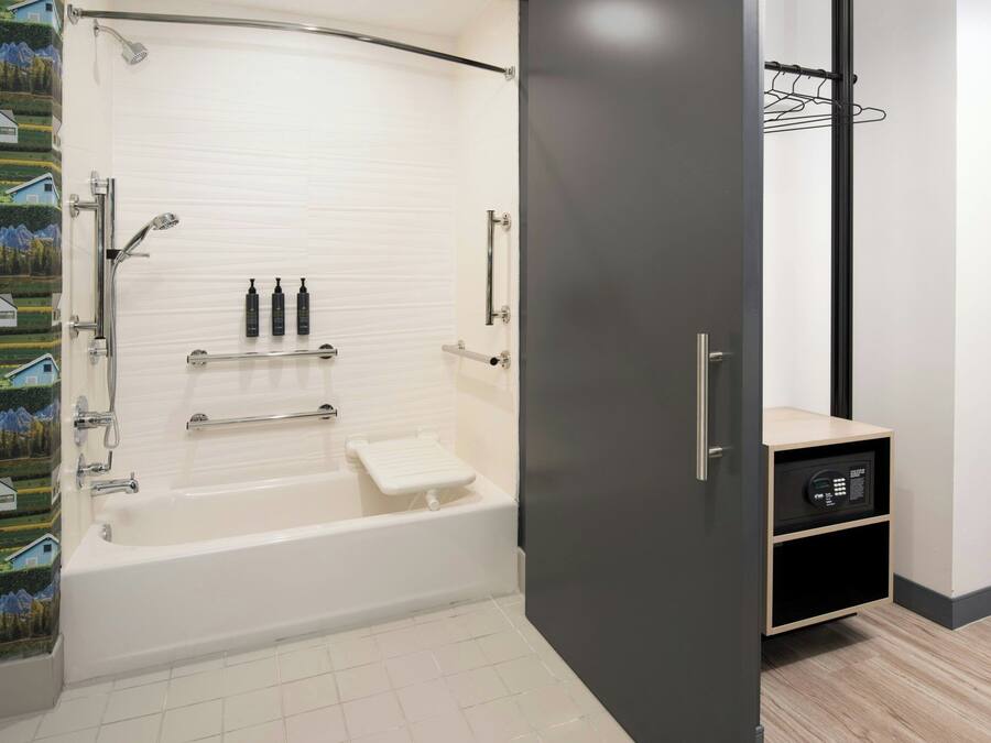 Un baño moderno con bañera, ducha y un perchero para toallas.