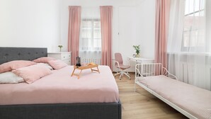 A bedroom with a bed, bedside table, chair, desk, and a window with curtains. - EASY RENT Apartments- OLD TOWN (Lublin)