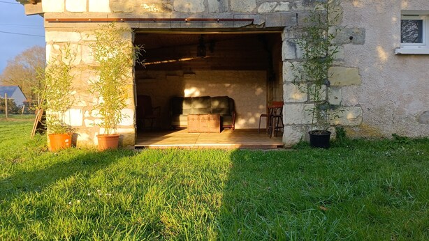 Un edificio rústico de piedra con una puerta de madera que da a un espacio interior.