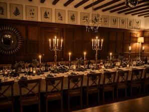 A formal dining room with a long table set for multiple guests, featuring candelabras, table settings, and framed botanical prints on the wall. - Balvonie House, Grand Scottish Mansion, Hot Tub with Island Views. 12 Bedrooms (Skelmorlie)