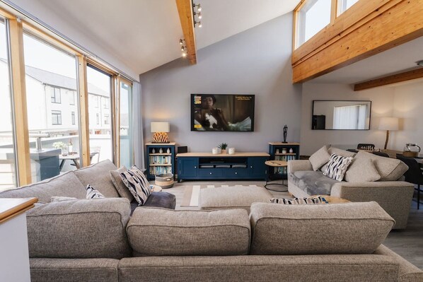 Bright open-plan living room with vaulted ceiling and skylights, upside-down holiday home in Rhosneigr, Anglesey