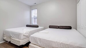 A bedroom with two single beds, a window with blinds, and a white wardrobe. - Suite 2 on Southport 4 Queen Beds (Chicago)
