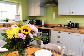 A kitchen with a wooden countertop, a toaster, a microwave, and a sink. - Stunning and Scenic Farmhouse | Perfect Setting (Nottingham)