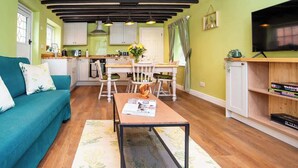Un espai habitable compacte amb cuina, zona de dinar i zona d'estar.