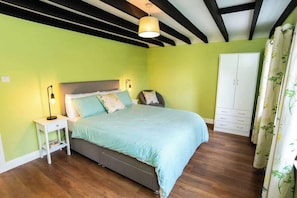 A bedroom with a bed, nightstands, a wardrobe, and a ceiling with exposed beams. - Stunning and Scenic Farmhouse | Perfect Setting (Nottingham)
