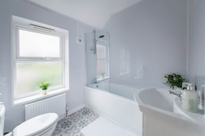 A bathroom with a toilet, a shower, and a sink.