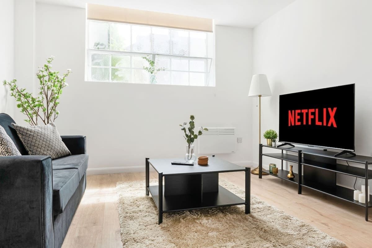 A modern living room with a sofa, a coffee table, a TV, and a window.