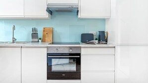 A kitchen with white cabinets, a built-in oven, a sink, and a toaster. - Charming Apartment | Free Parking and Wi-Fi (Newark-on-Trent)