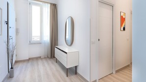 A modern, well-lit room with a white dresser, a mirror, and a door. - Brand new Central Sorrento 2 BR 2 BT Flat AC Wifi Parking Balcony (Sorrento)