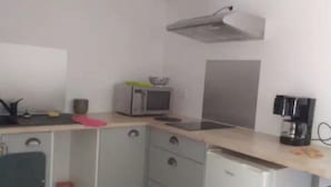 Eine kleine Küche mit einer Mikrowelle, einer Kaffeemaschine und einem kleinen Kühlschrank.