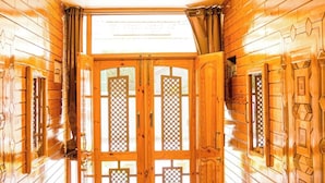 A wooden hallway with a double door, a tiled floor, and a ceiling light. - Arbiya Villa (Srinagar)