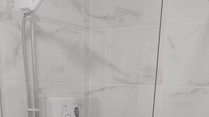 A glass-enclosed shower stall with a handheld showerhead and a control panel. - Stylish, Comfy 1BD with Cathedral Neighbour (Dublin)