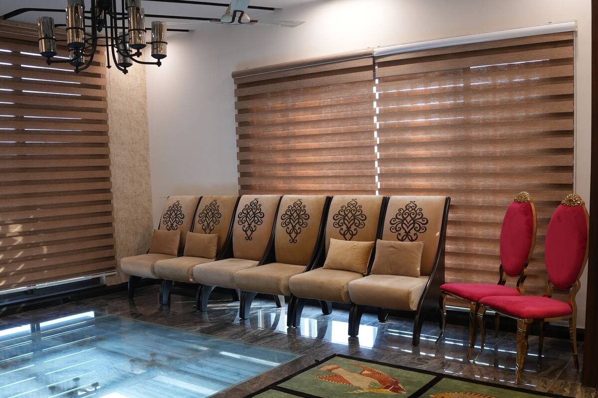 Un espace d’attente avec une piscine, des chaises et un ventilateur de plafond.