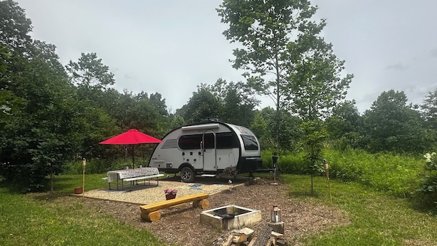 A camper parked in a grassy area with a picnic table, a red umbrella, and a fire pit. - Cozy RV on 149 acres in Charleston with AC, WiFi, and eight miles of trails!


 (Charleston)