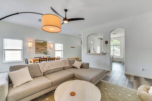 A modern living room with a sectional sofa, a round coffee table, and a ceiling fan.