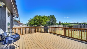 A wooden deck with a grill and a chair, surrounded by a wooden fence and trees. - Pet-friendly Moclips Home: Walk to Mocrocks Beach! (Moclips)