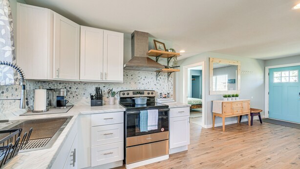 A modern kitchen with white cabinets, a stainless steel range hood, and a built-in oven. - Pet-friendly Moclips Home: Walk to Mocrocks Beach! (Moclips)