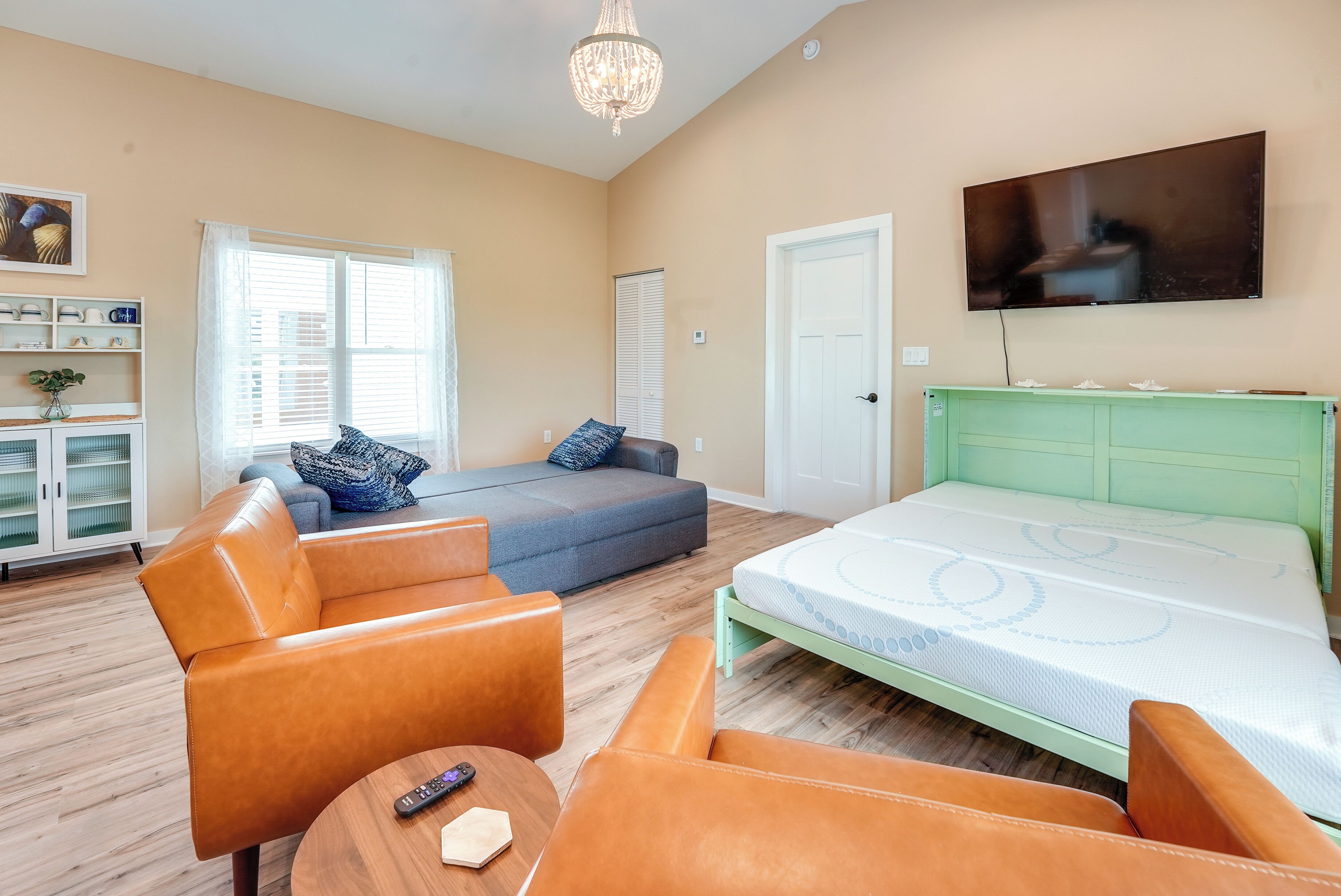 A bedroom with a bed, a sofa, and a TV.