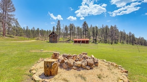 A rustic cabin with a red roof, surrounded by a forested area and a clear sky. - Remote Custer Cabin w/ Fire Pit & Near State Park! (Custer)