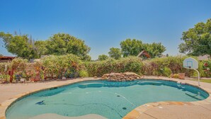 A swimming pool with a basketball hoop, surrounded by trees and plants. - Sunny Stephenville Home w/ Pool: 4 Mi to Downtown (Stephenville)