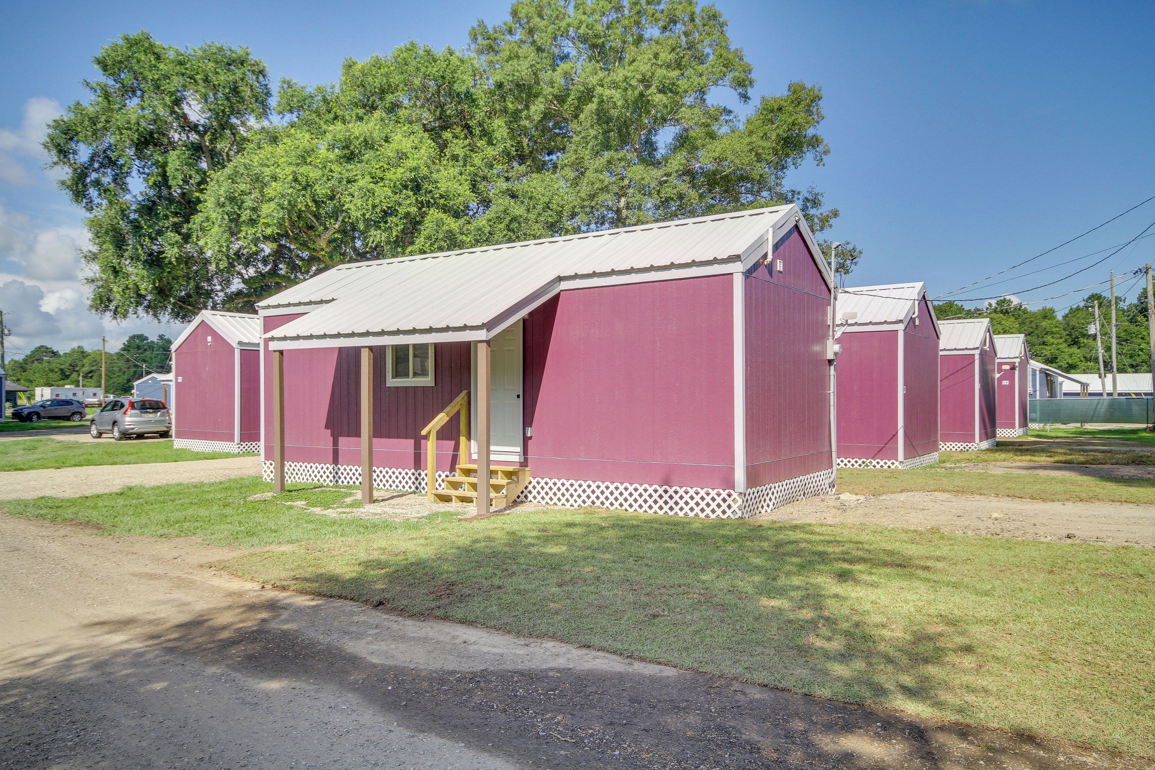 A row of red mobile homes with white trim and a small porch area.