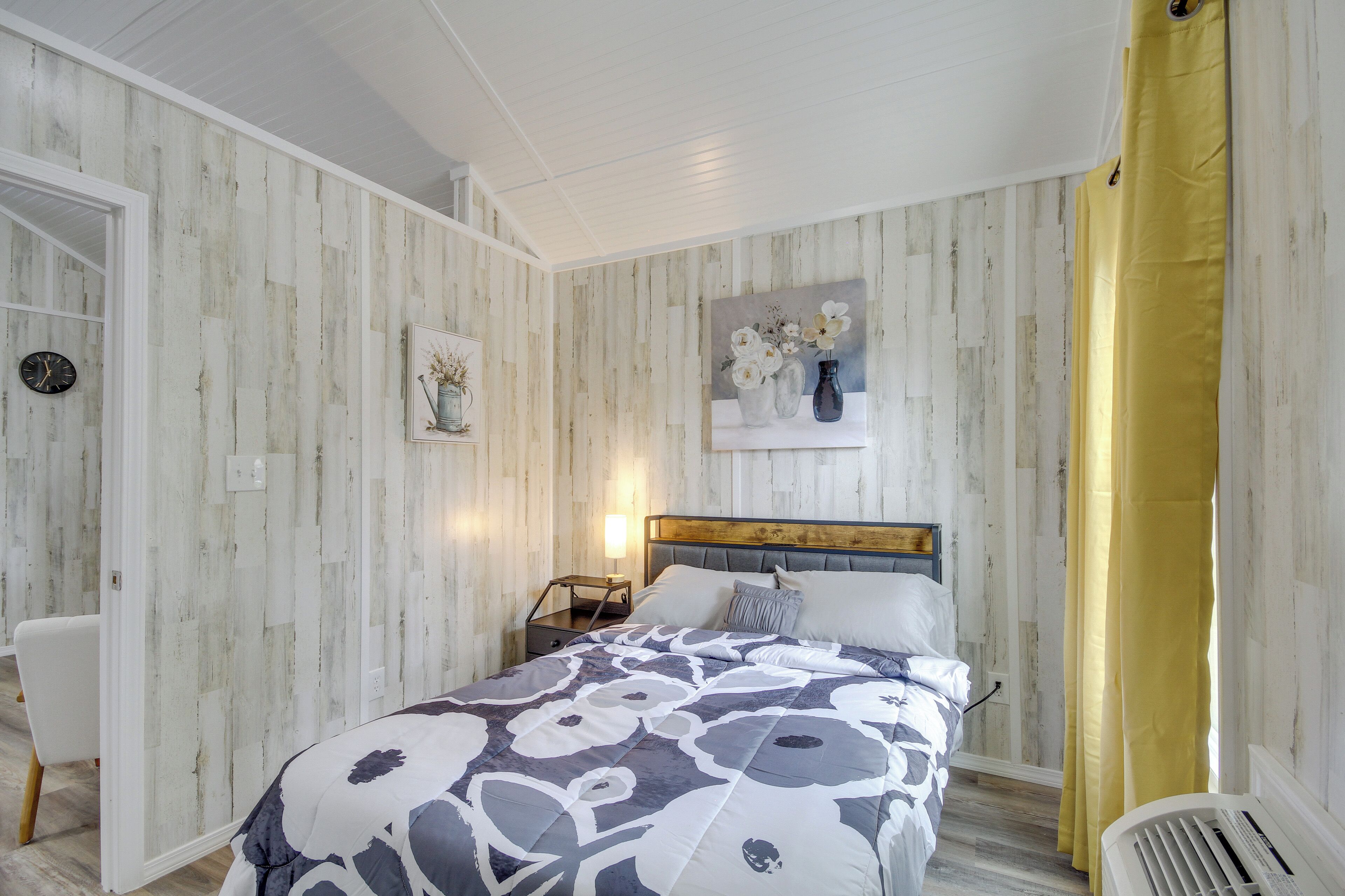 A bedroom with a bed, bedside table, and a nightstand.