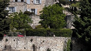 A stone building with a tiled roof, surrounded by trees and a stone wall. - From the top of its terraces and garden, breathtaking views of the Luberon  (Murs)