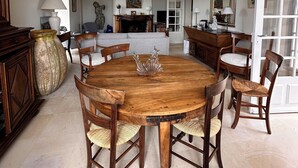 A dining area with a wooden table and chairs, a chandelier, and a large vase. - From the top of its terraces and garden, breathtaking views of the Luberon  (Murs)