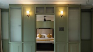 Une chambre à coucher avec un lit, deux lampes fixées au mur et un ventilateur de plafond.