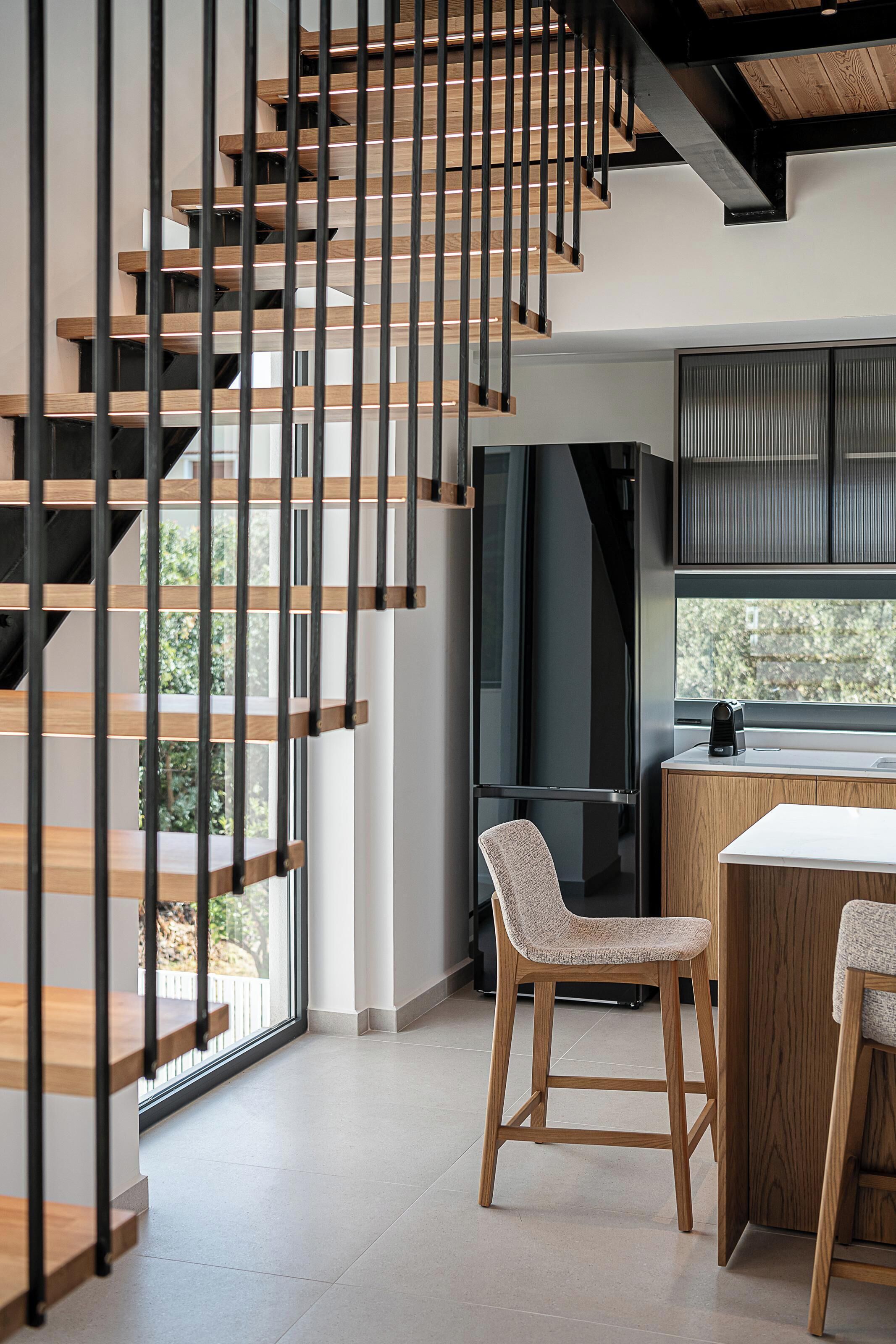 Una cocina moderna con encimera de madera, horno empotrado y ventana con vistas a zonas verdes.