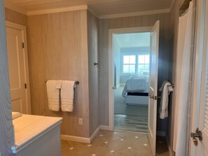 A bathroom with wooden paneling, a white sink, and a towel rack. - Cheers - Your Perfect Beachfront Escape with Private Dock Slip Pool Ocean (Hope Town)