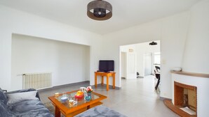 Ein modernes Wohnzimmer mit einer Couch, einem Couchtisch und einem Kamin.