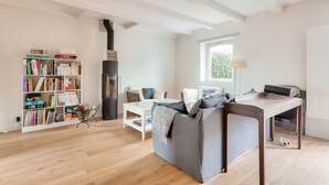 A modern living room with a sofa, a coffee table, a bookshelf, and a fireplace. - Seaview, house for 7 Golfe du Morbihan (Sarzeau)