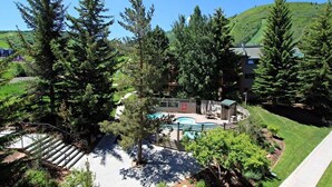 A resort with a pool, surrounded by trees and a building with a sloped roof. - Snow Flower 068 3 Bedroom Condo by RedAwning (Park City)