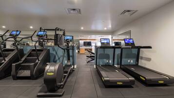 A gym with treadmills, elliptical machines, and exercise bikes.