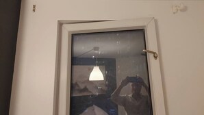 Eine Tür mit Glasscheibe, weißem Rahmen und erkennbarem Griff.