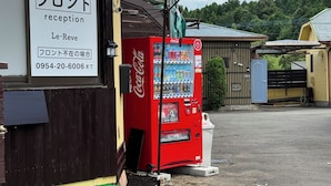En bygning med et receptionsskilt, en Coca-Cola automat og en grøn markise.