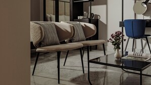 Een moderne woonkamer met een bank, een blauwe fauteuil, een salontafel en een tijdschrift.