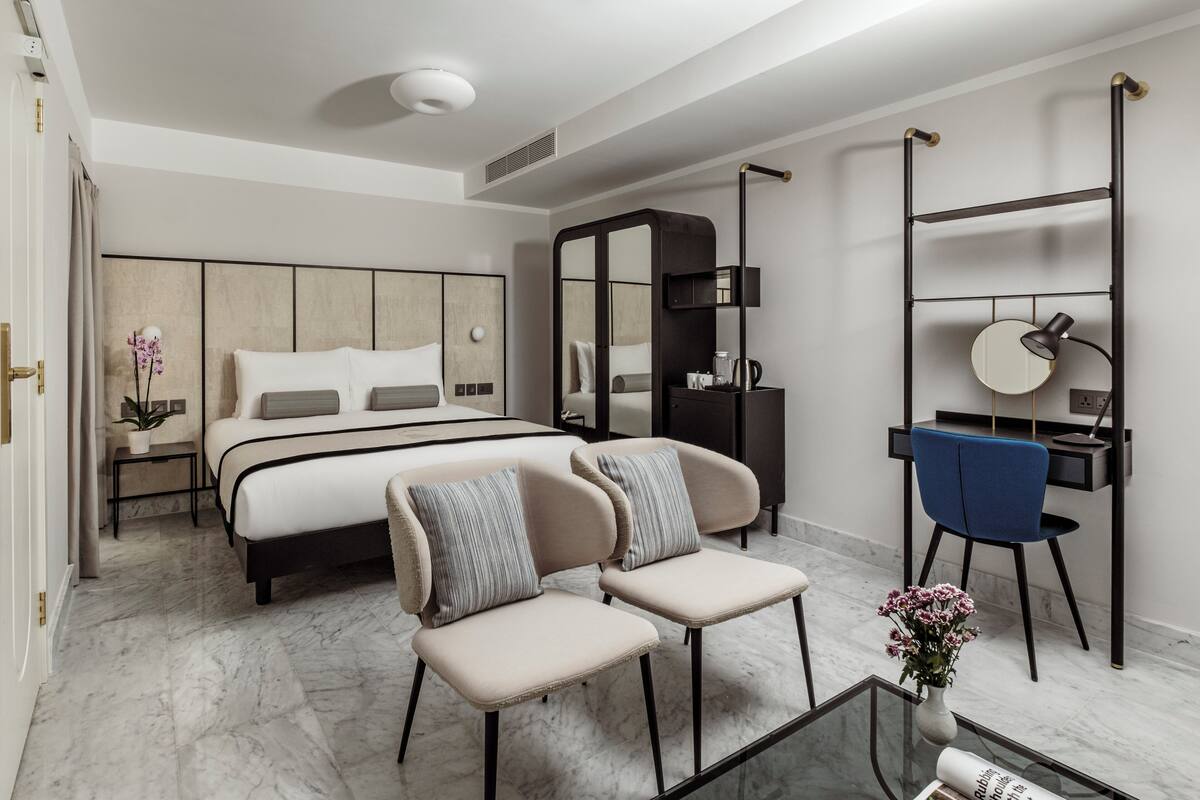 Un dormitorio moderno con una cama grande, un escritorio y una silla.