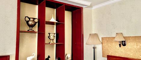 A room with a red-framed window, a lamp, and a bed.