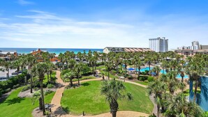 Ein Resort mit Pool, Palmen und Blick auf den Ozean.