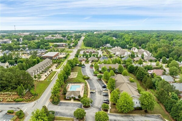 Vista aérea de una zona residencial con casas, carreteras y una piscina.