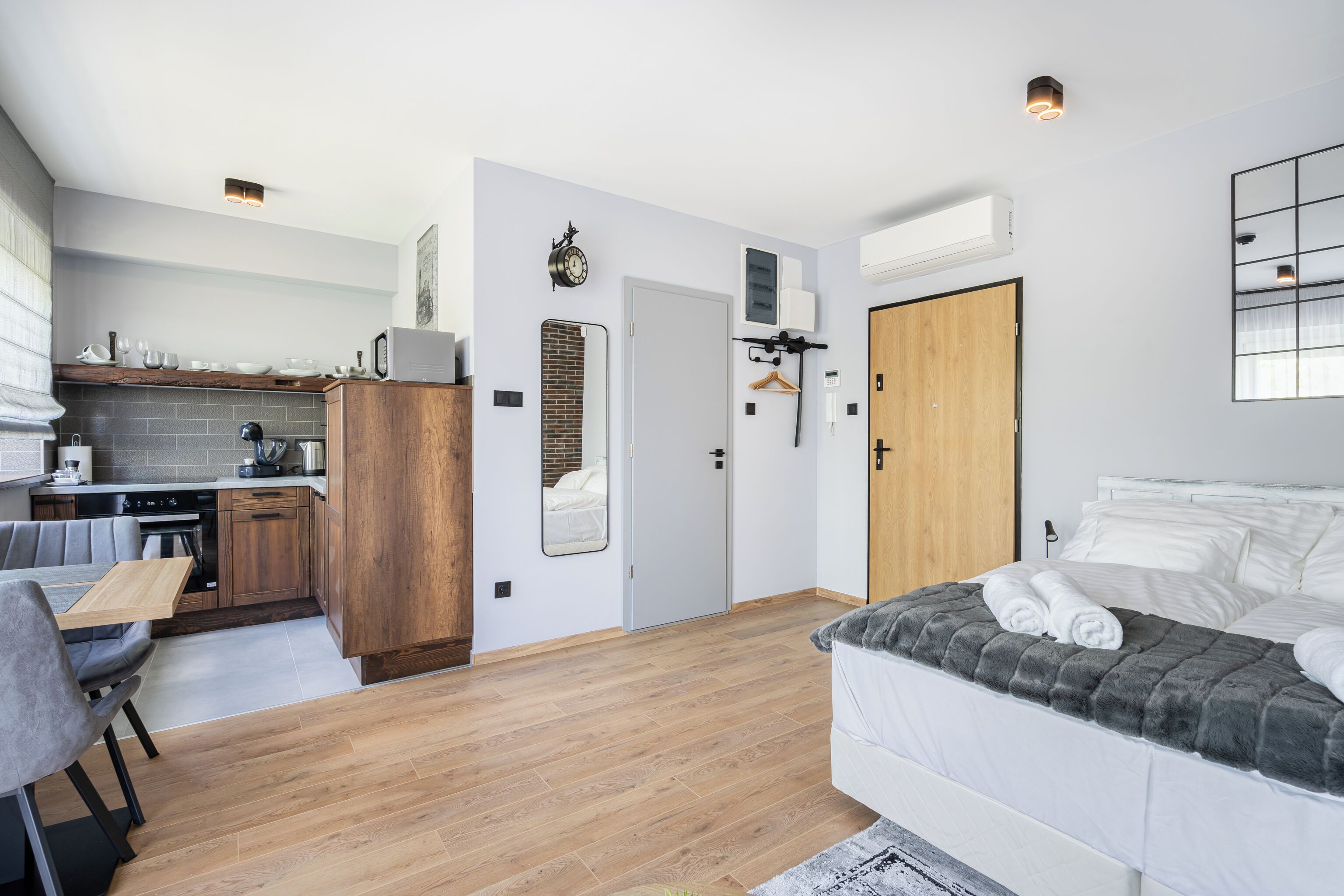 Een moderne slaapkamer met een bed, nachtkastje en uitzicht op de keuken.