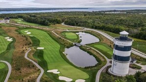 Ein Golfplatz mit Bunkern, Wasserhindernissen und einem Leuchtturm.