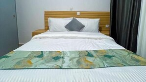 A single bed with a wooden headboard, white bedding, and a patterned throw blanket. - Rebero View Apartments (Kigali)