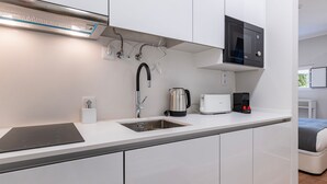 A modern kitchen with a built-in microwave, kettle, and coffee maker. - Noah's Ark by LovelyStay (Cascais)
