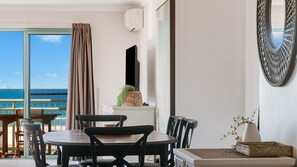 A balcony with a table and chairs, a potted plant, and a view of the ocean. - Golden Sea 12 - Absolute Beachfront Bilinga - Min. 3 Night Stays! (Bilinga)