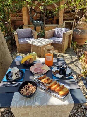 An outdoor dining area with a table set for breakfast, including bread, fruit, and a beverage. - B&B Firenze 400  (Florence)