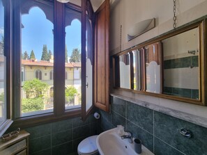 A bathroom with a toilet, sink, and window. - B&B Firenze 400  (Florence)
